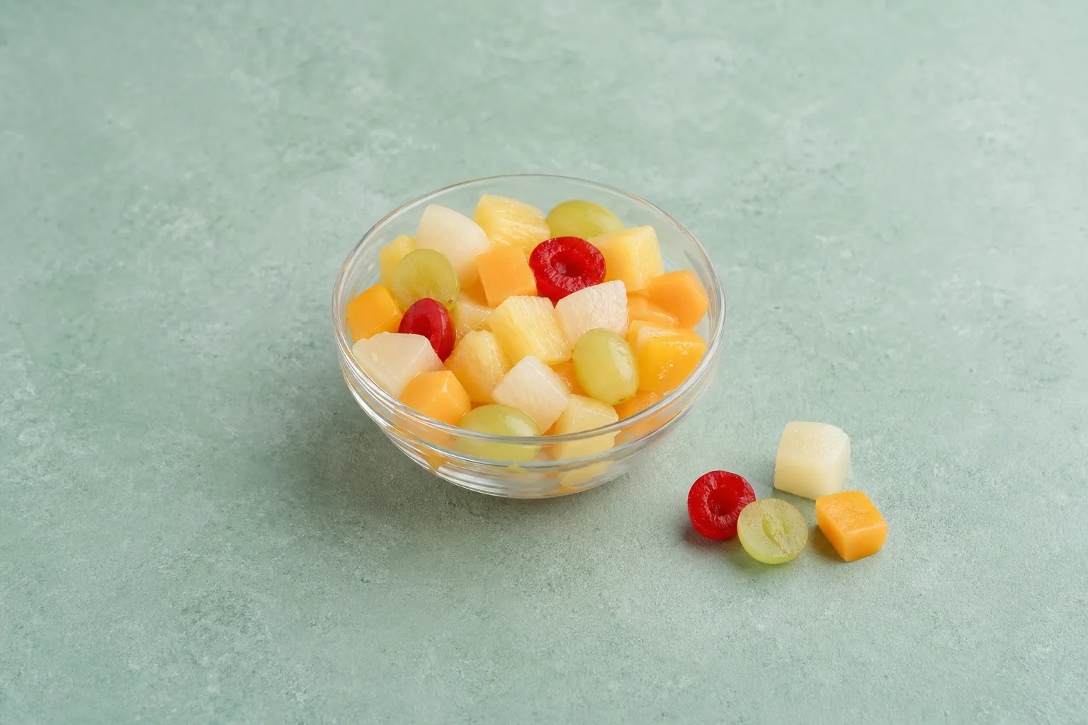 Drained canned fruit cocktail pieces in a clear bowl with no pooled syrup.