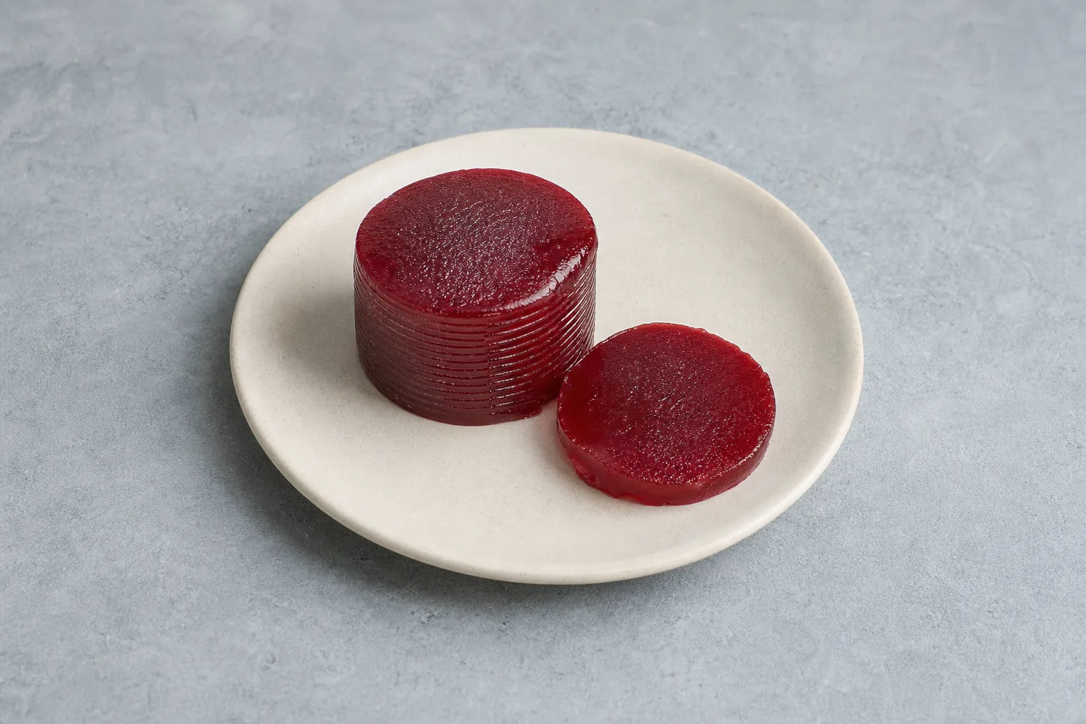 Glossy deep-red canned cranberry sauce with one clean round slice.
