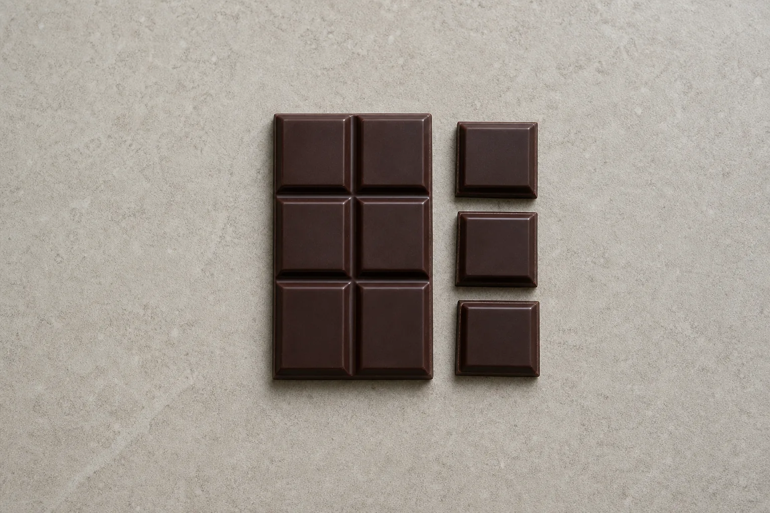 A plain six-square dark-chocolate bar with three separate squares beside it.