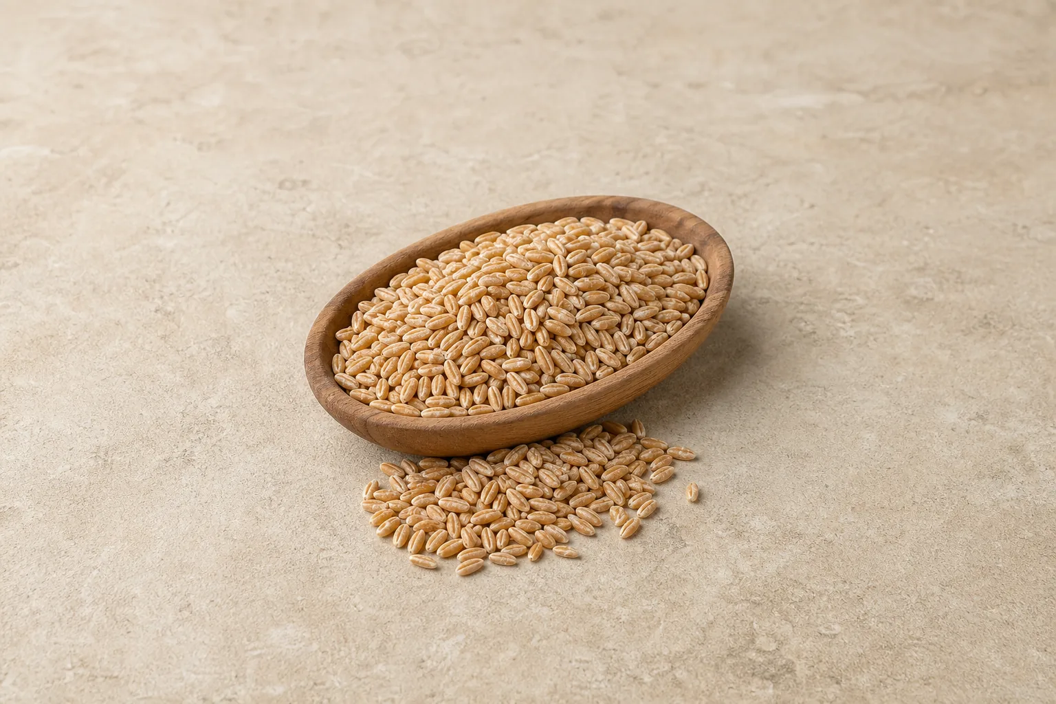 A wooden scoop of dry tan pearled farro with a small spill of grains.