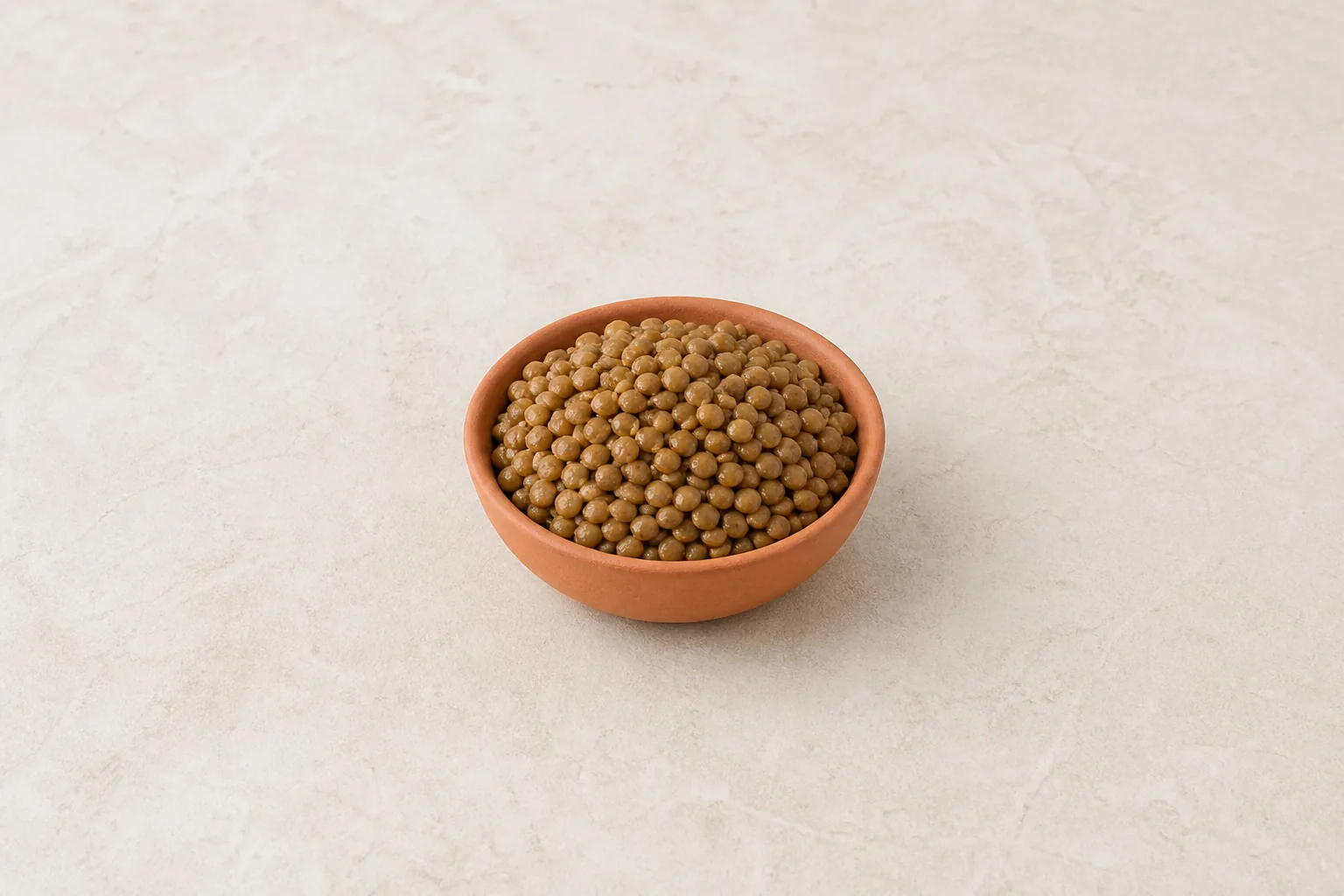 A bowl of plain cooked brown-green lentils with tender intact grains.