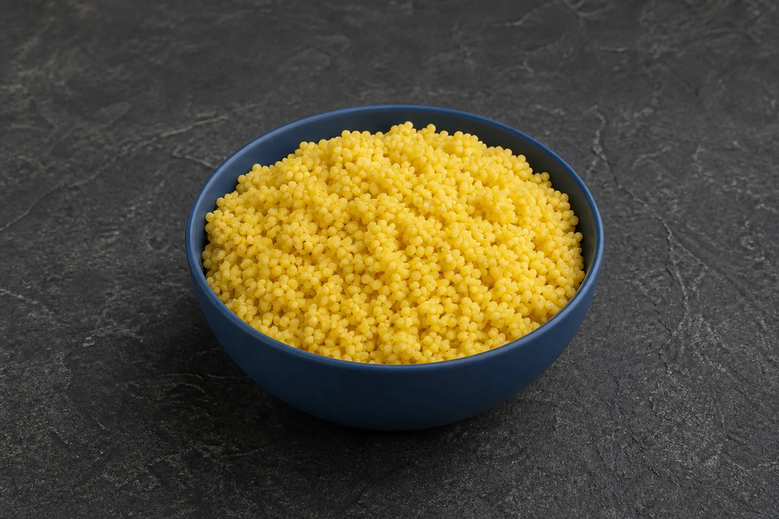 A small bowl of plain cooked millet with tiny soft golden-yellow grains and slight natural clumping.